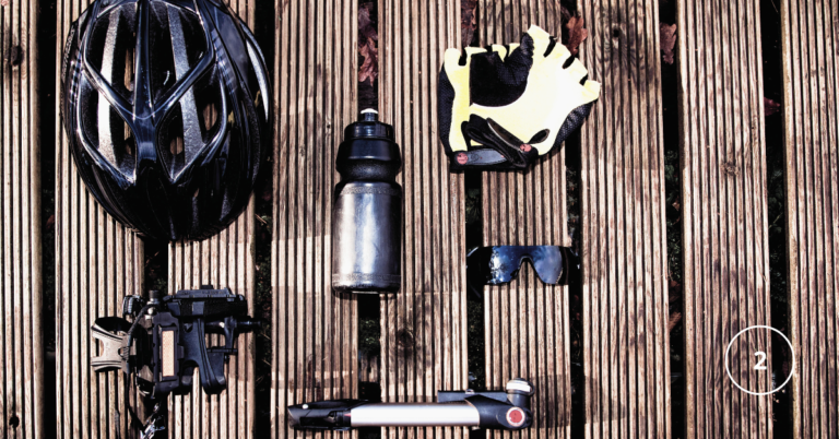 a collection of cycling gear laid out on a wooden deck